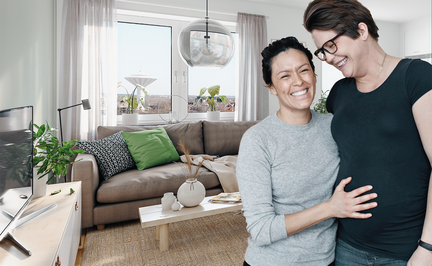 Två kvinnor kramas och skrattar i vardagsrum.