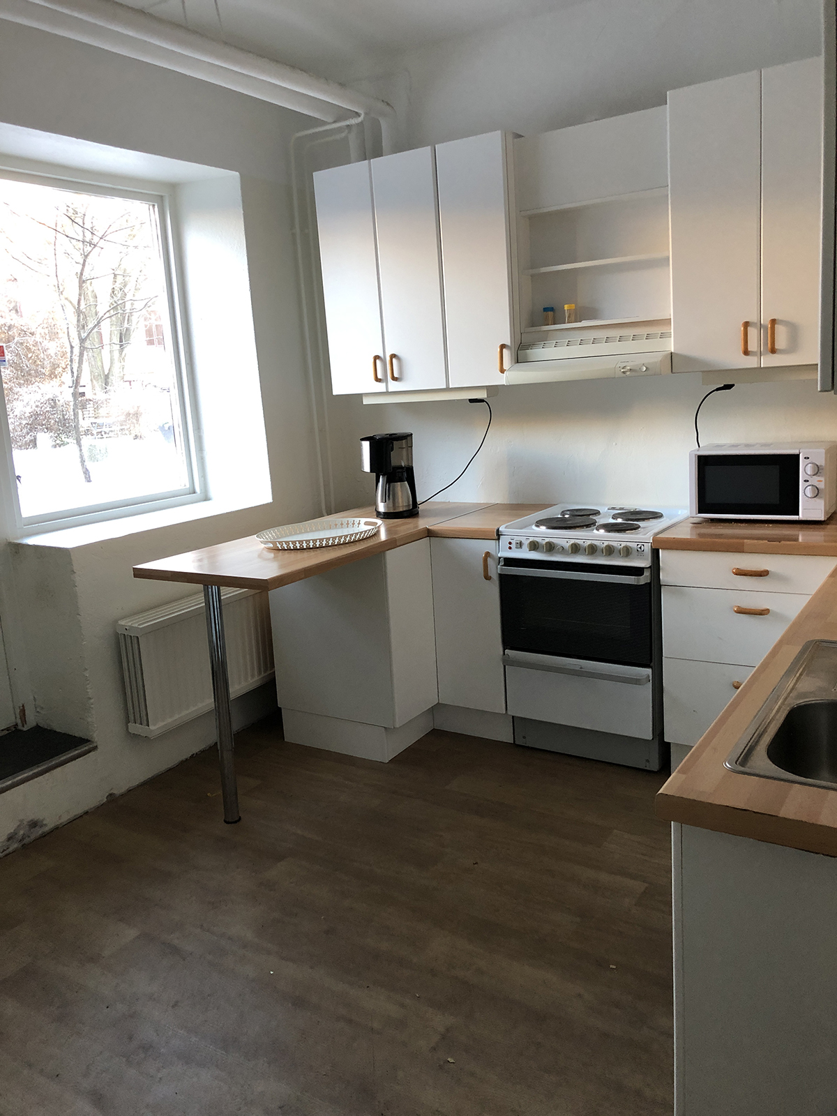 Köksdel med spis och diskho.