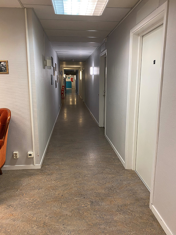 Lång korridor med dörrar in till flertalet rum