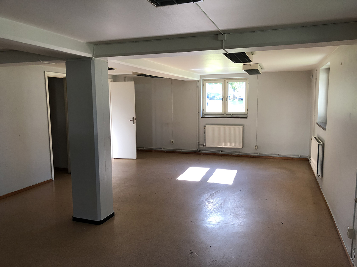 Del i lokal med vitmålade väggar och fönster med ljusinsläpp.