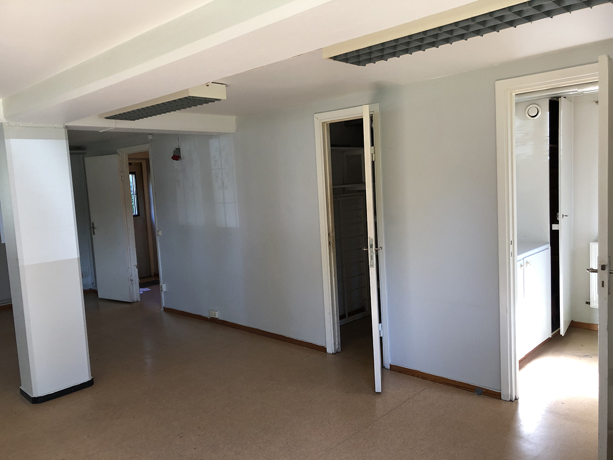 Del av lokal med dörrar in till pentry, förråd och kapprum.